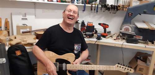 Smiling musician playing a Tim Marten DoubleTake guitar.