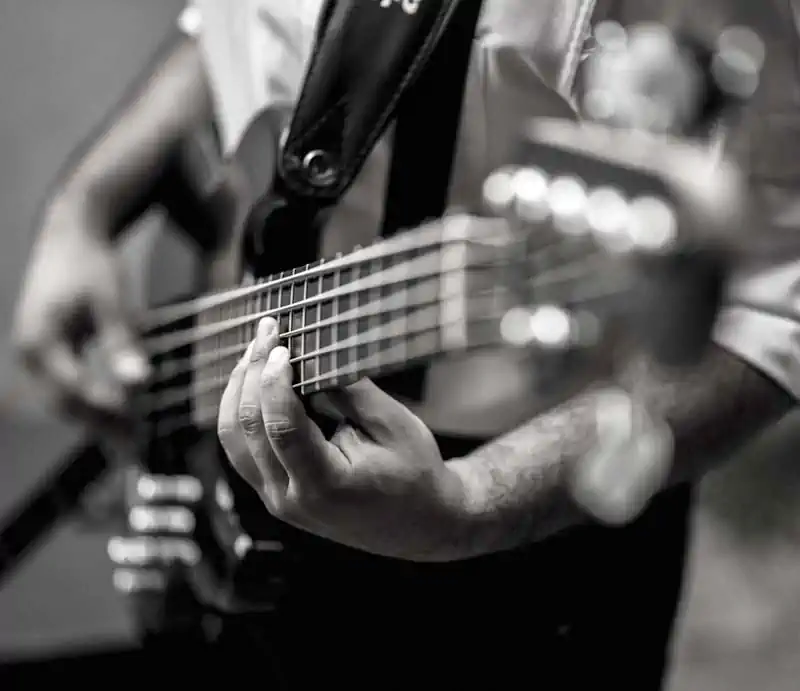A black-and-white, shallow depth-of-field shot highlighting a musician